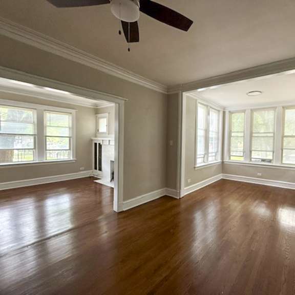 a room with wooden floors and a ceiling fan.