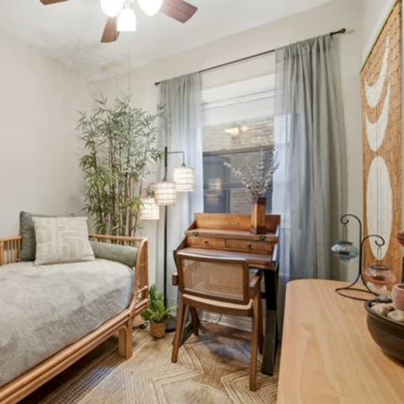 a bedroom with a bed, desk, and chair.