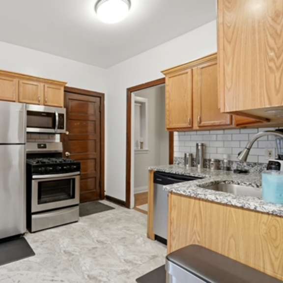a kitchen with wooden cabinets and a stainless steel refrigerator.