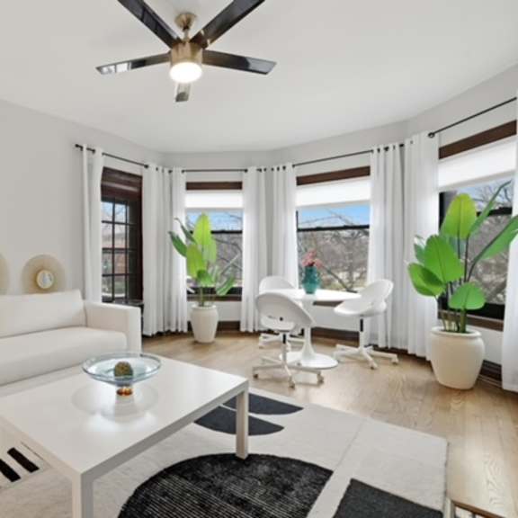 a white living room with a couch, coffee table, and plants.