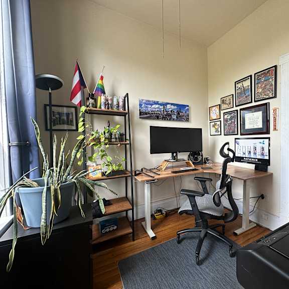 a room with a desk, chair, and exercise bike.