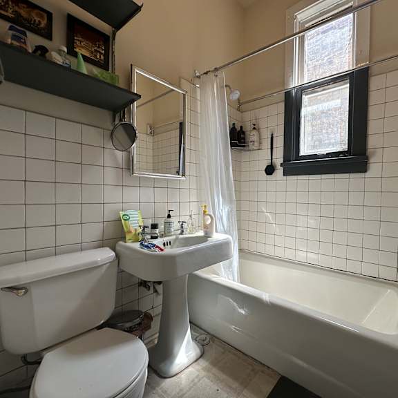 a white toilet sits next to a white sink in a small bathroom.