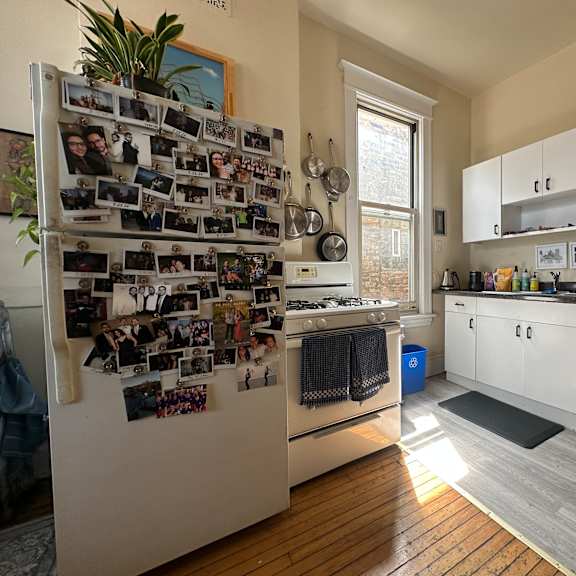 a kitchen with a refrigerator covered in photos.