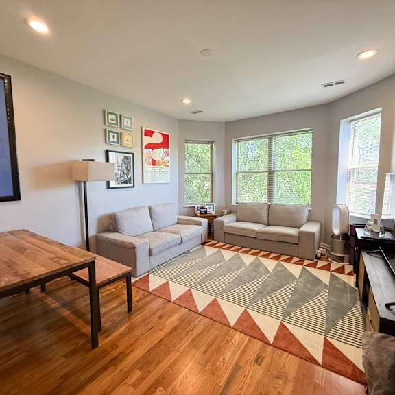 a living room with a couch, a chair, a coffee table, and a television.