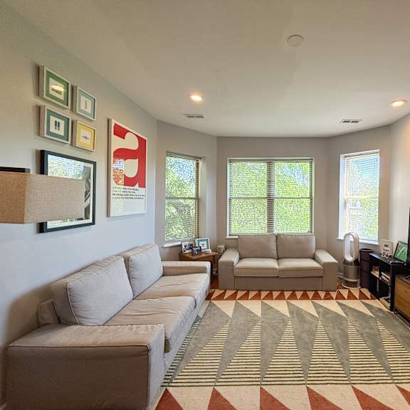 a living room with a large couch, a chair, and a television.