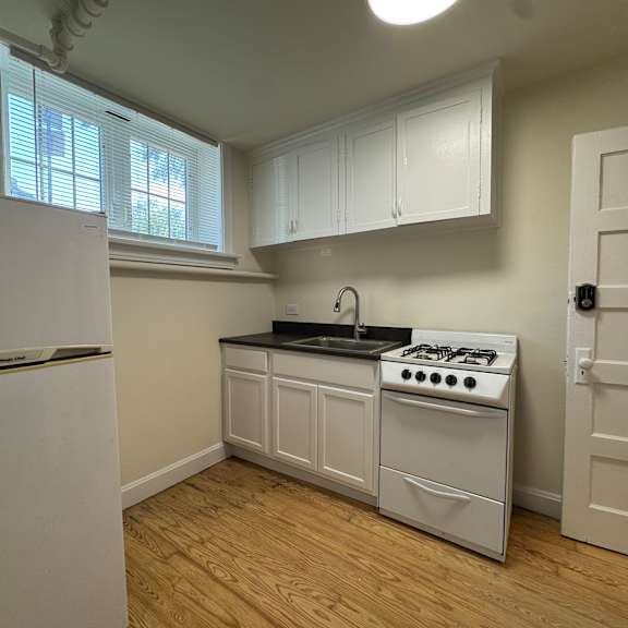a kitchen with a white stove and cabinets.