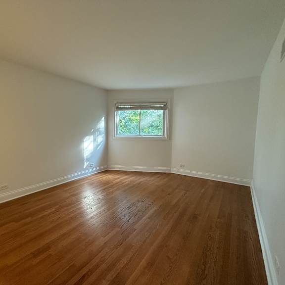 a room with wooden flooring and a window.