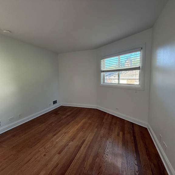 a room with wooden flooring and a window.