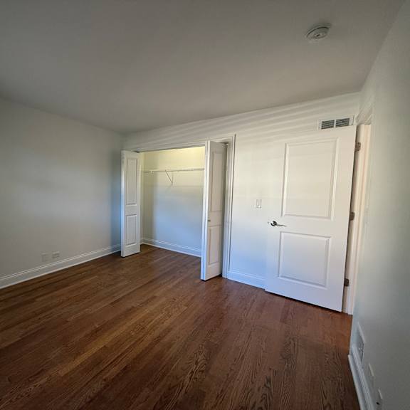 a room with wooden floors and white walls.