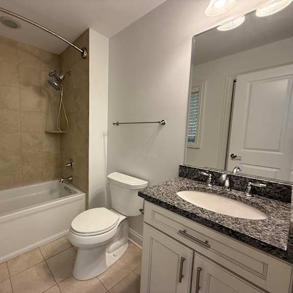 a white toilet sits next to a bathtub in a bathroom.