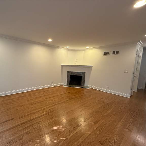 a room with a fireplace and wooden flooring.