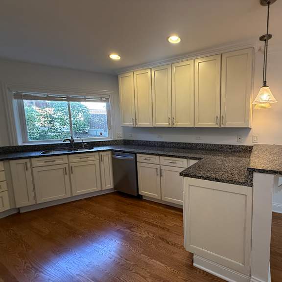 a kitchen with white cabinets and a granite countertop.