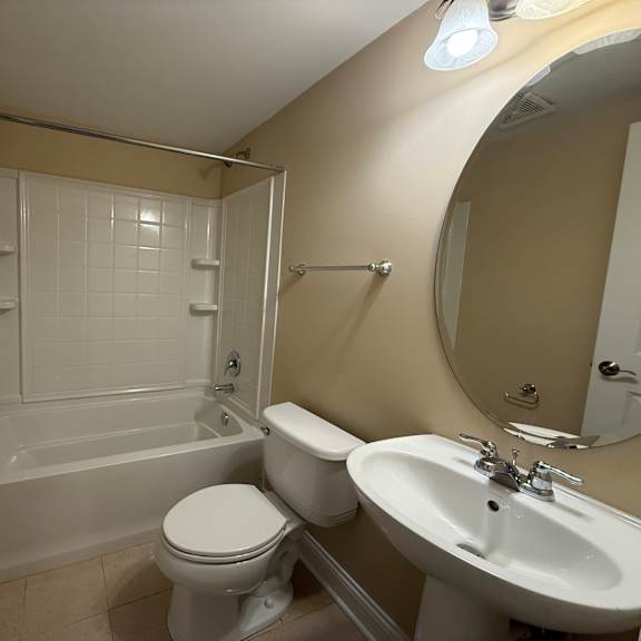 a white toilet sits next to a white sink in a bathroom.