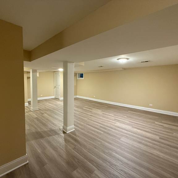 a room with wooden flooring and white columns.