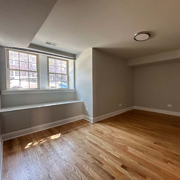 a room with wooden flooring and a window.