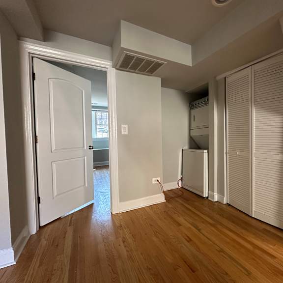 a room with a white door and wooden floors.