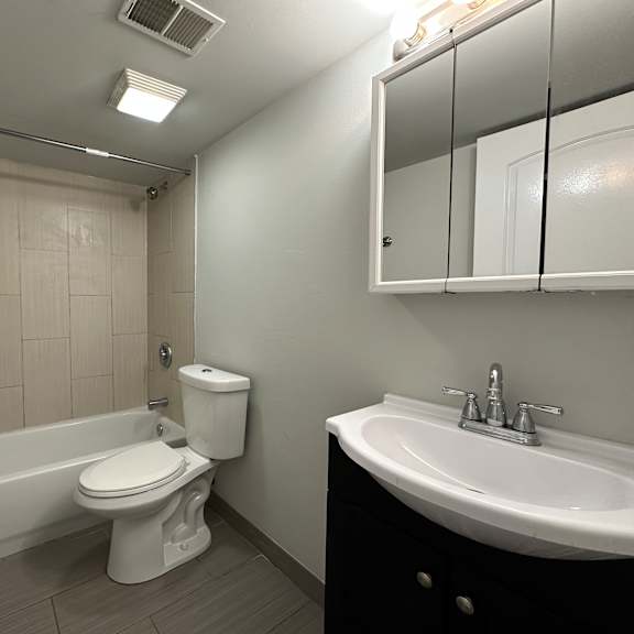 a white toilet sits next to a white sink in a bathroom.