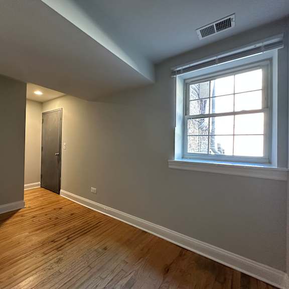 a room with a wooden floor and a window.