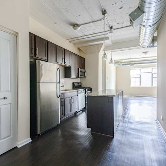 a kitchen with a refrigerator, oven, and cabinets.