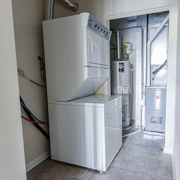 a white refrigerator and freezer are in a room with a door leading outside.