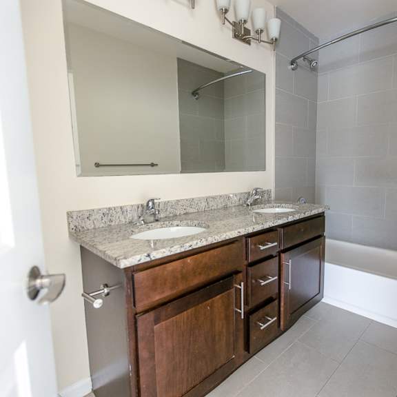 a bathroom with a sink, mirror, and bathtub.