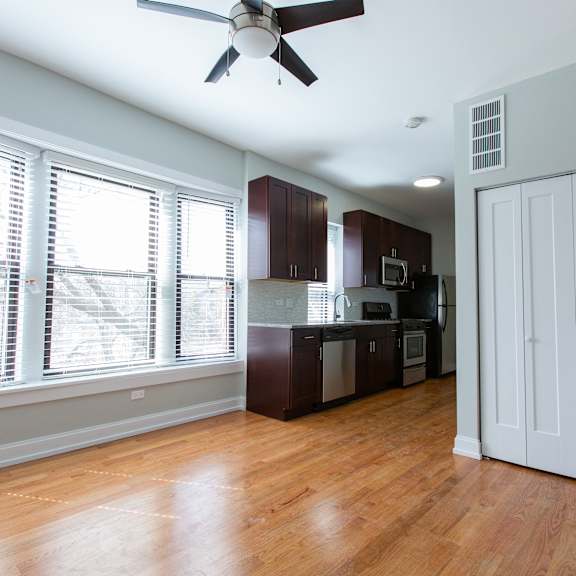 a room with a ceiling fan and wooden floors.