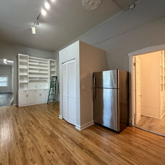 a kitchen with a refrigerator and wooden floors.