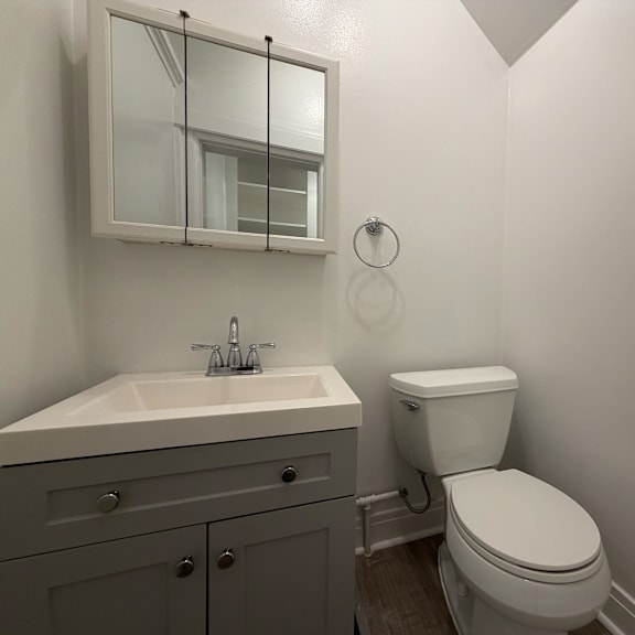 a white toilet sits next to a sink in a bathroom.