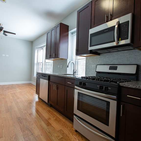 a kitchen with dark wood cabinets and stainless steel appliances.