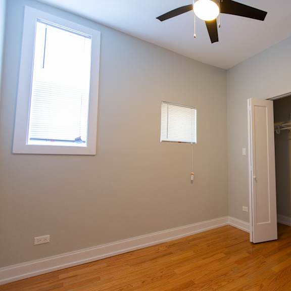 a room with a ceiling fan and a closet.