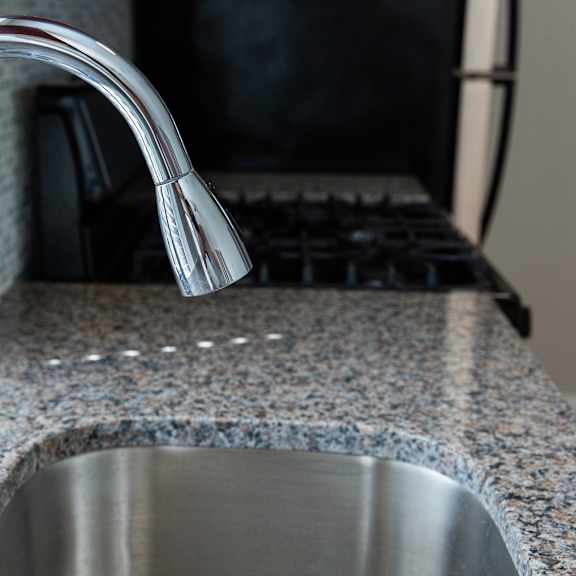 a kitchen sink with a chrome faucet.