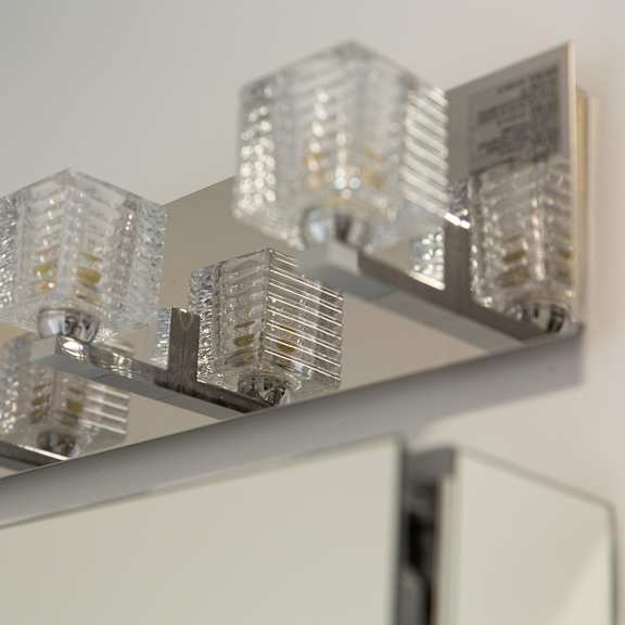 a wall-mounted light fixture with multiple clear glass panels.