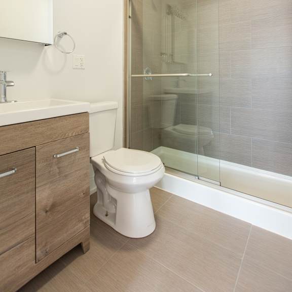a white toilet sits next to a sink in a modern bathroom.