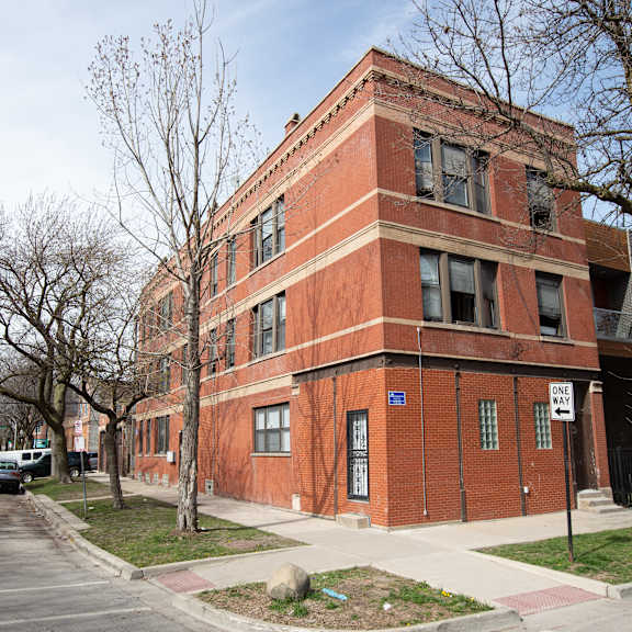 a red brick building with a tree in front of it.