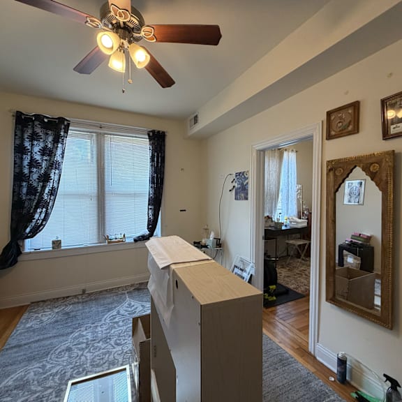 a room with a ceiling fan and a large mirror on the wall.