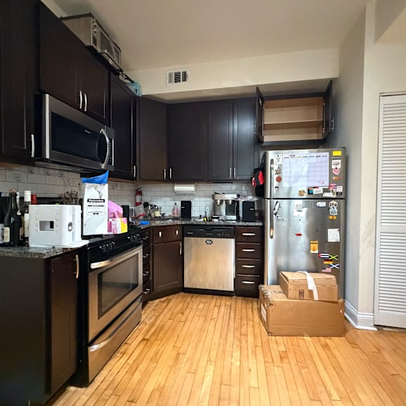 a kitchen with black cabinets and a white fridge.