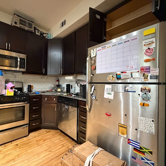 a kitchen with a refrigerator covered in magnets and papers.