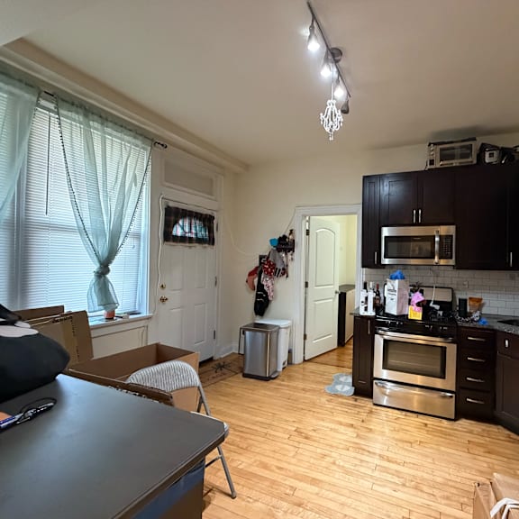 a kitchen with wooden floors and black cabinets.