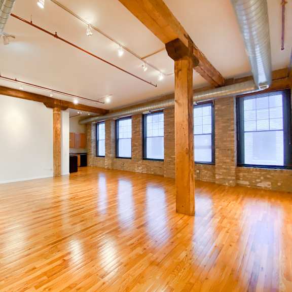 a large room with wooden floors and exposed beams.