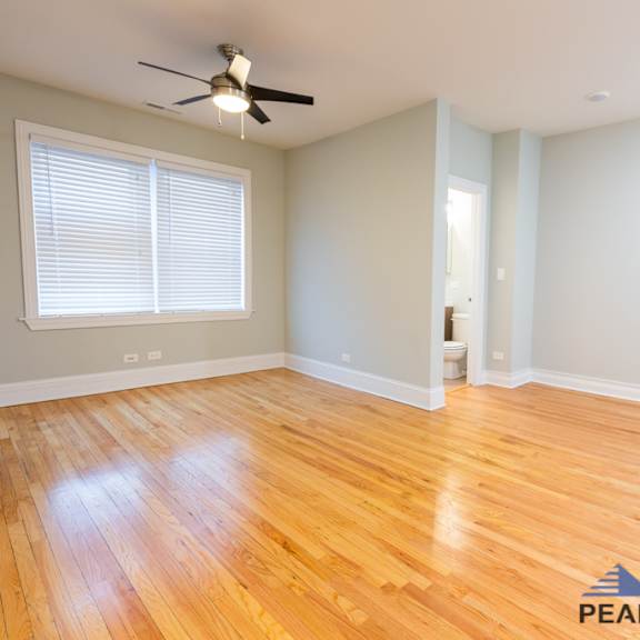 a room with wooden floors and a ceiling fan.