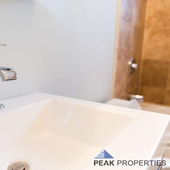 a white sink with a chrome faucet in a bathroom.