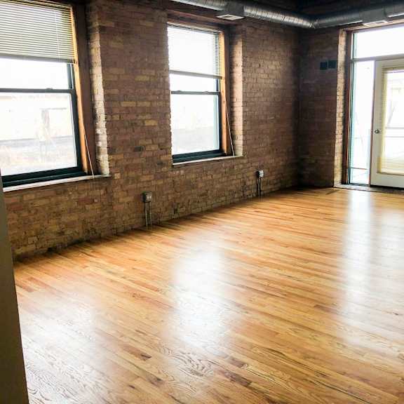 a room with wooden floors and brick walls.