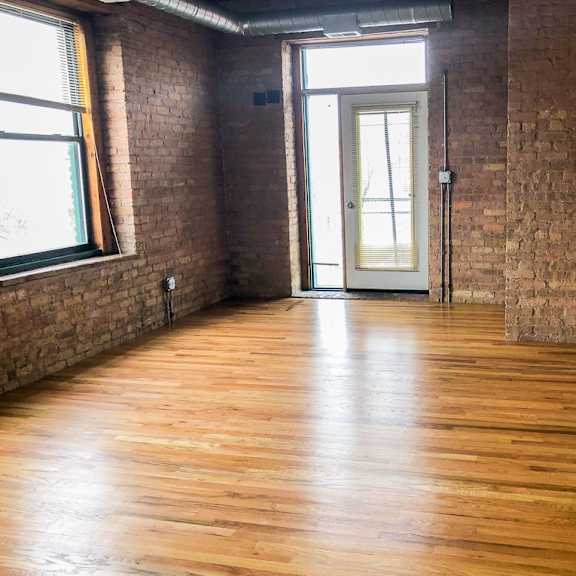 a room with wooden floors and a brick wall.