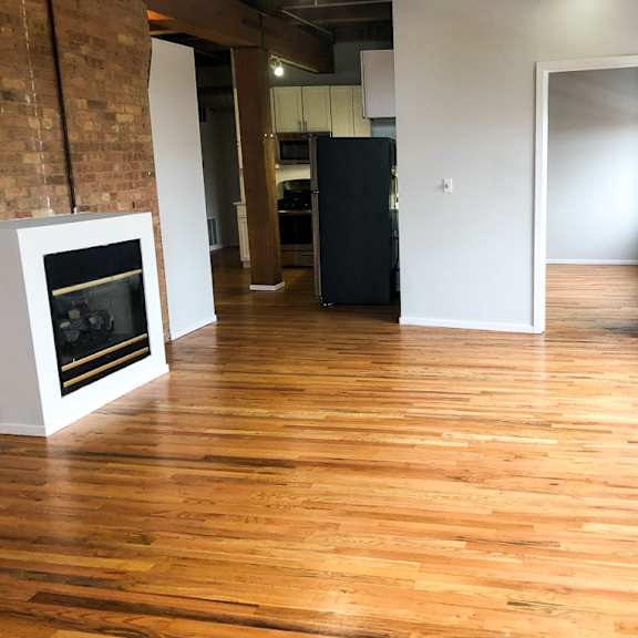 a room with wooden floors and a fireplace.