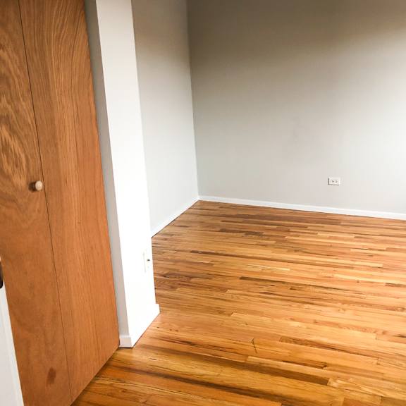 a room with wooden flooring and a wooden door.