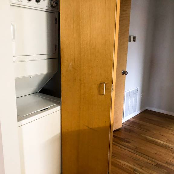 a white oven and dishwasher are built into a wooden cabinet.