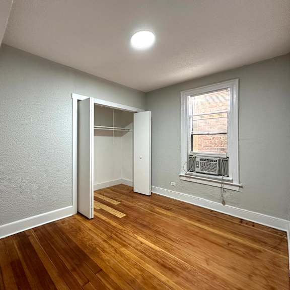 a room with a wooden floor and a window.
