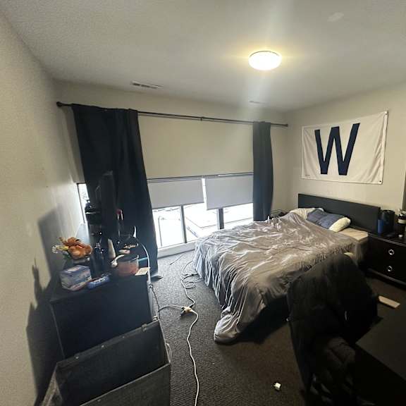 a bedroom with a bed, desk, and chair.