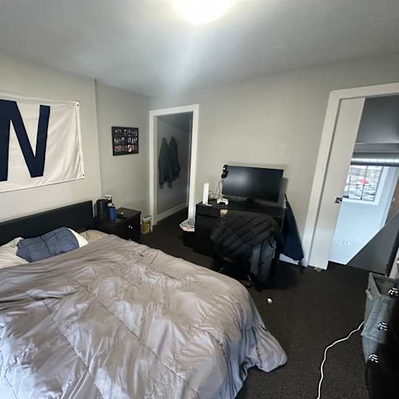 a bedroom with a bed, a dresser, and a wall hanging with the letter w on it.