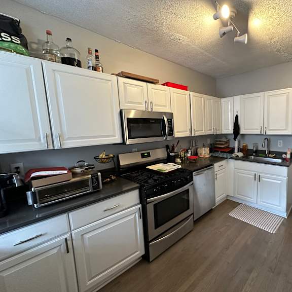 a kitchen with white cabinets and black appliances.